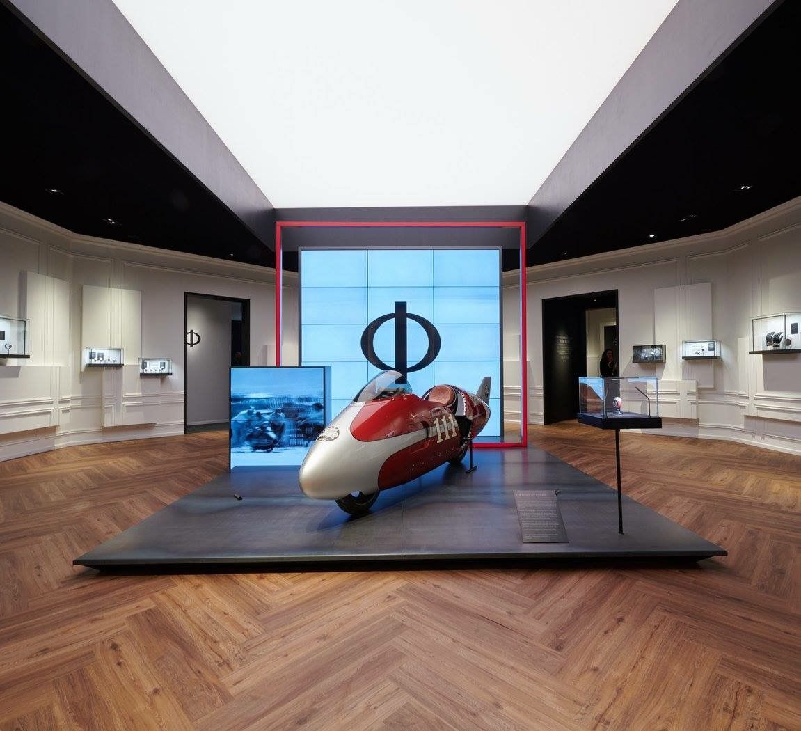 Ein rot-weißes Motorrad ist in einem Museum ausgestellt