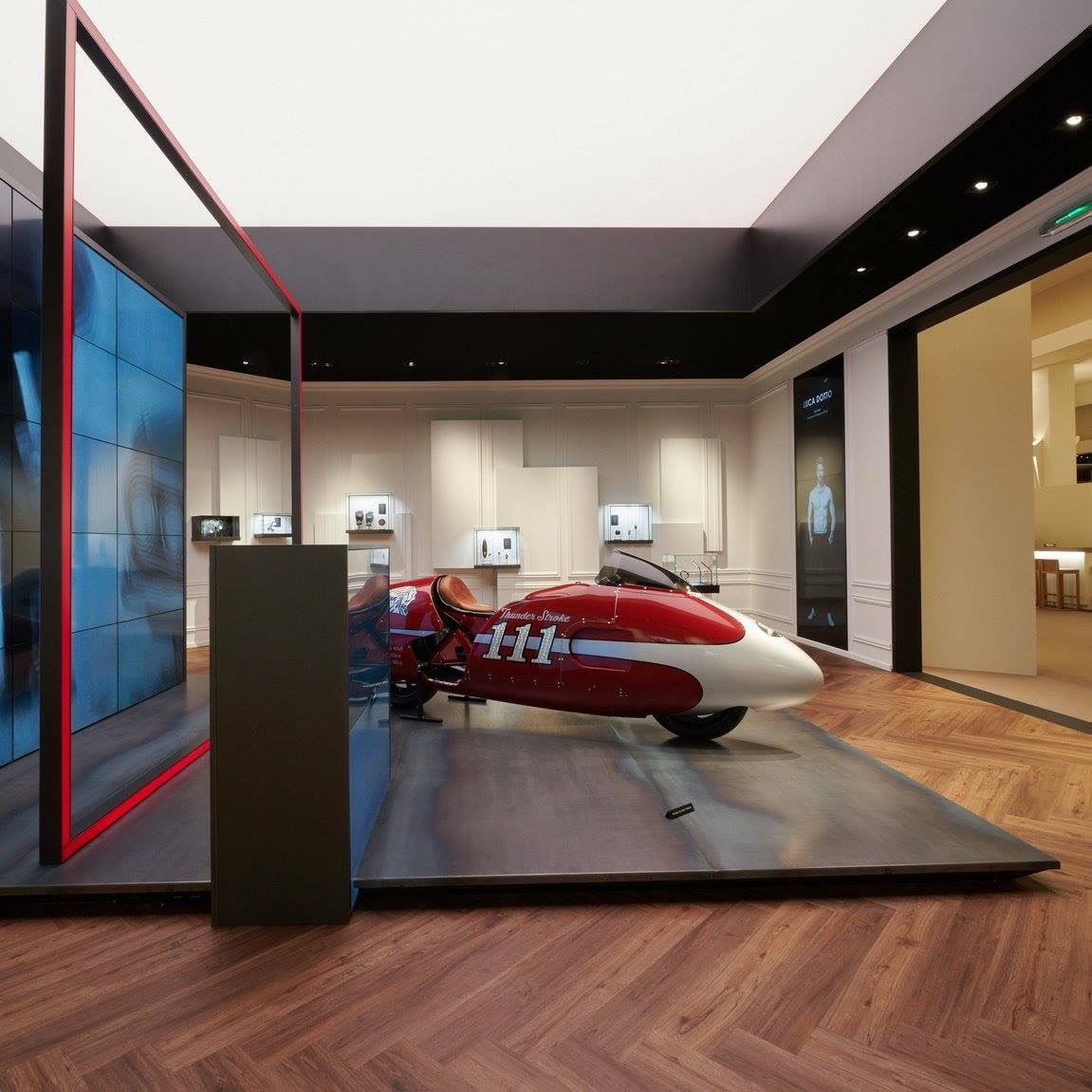 In einem Raum ist ein rot-weißes Motorrad ausgestellt