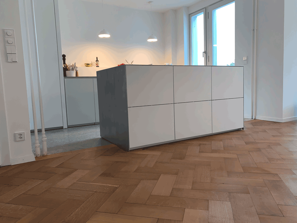 Eine Küche mit einer großen Insel in der Mitte und einem Holzboden.