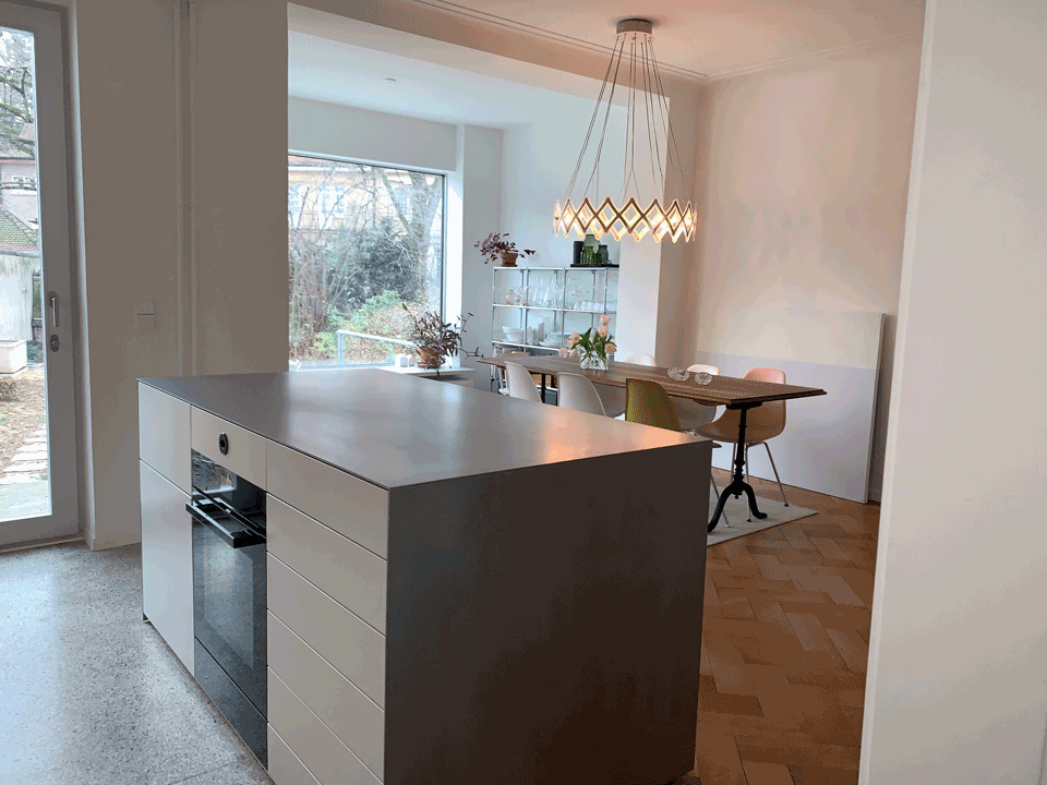 Eine Küche mit großer Kochinsel und einem Esszimmer im Hintergrund.