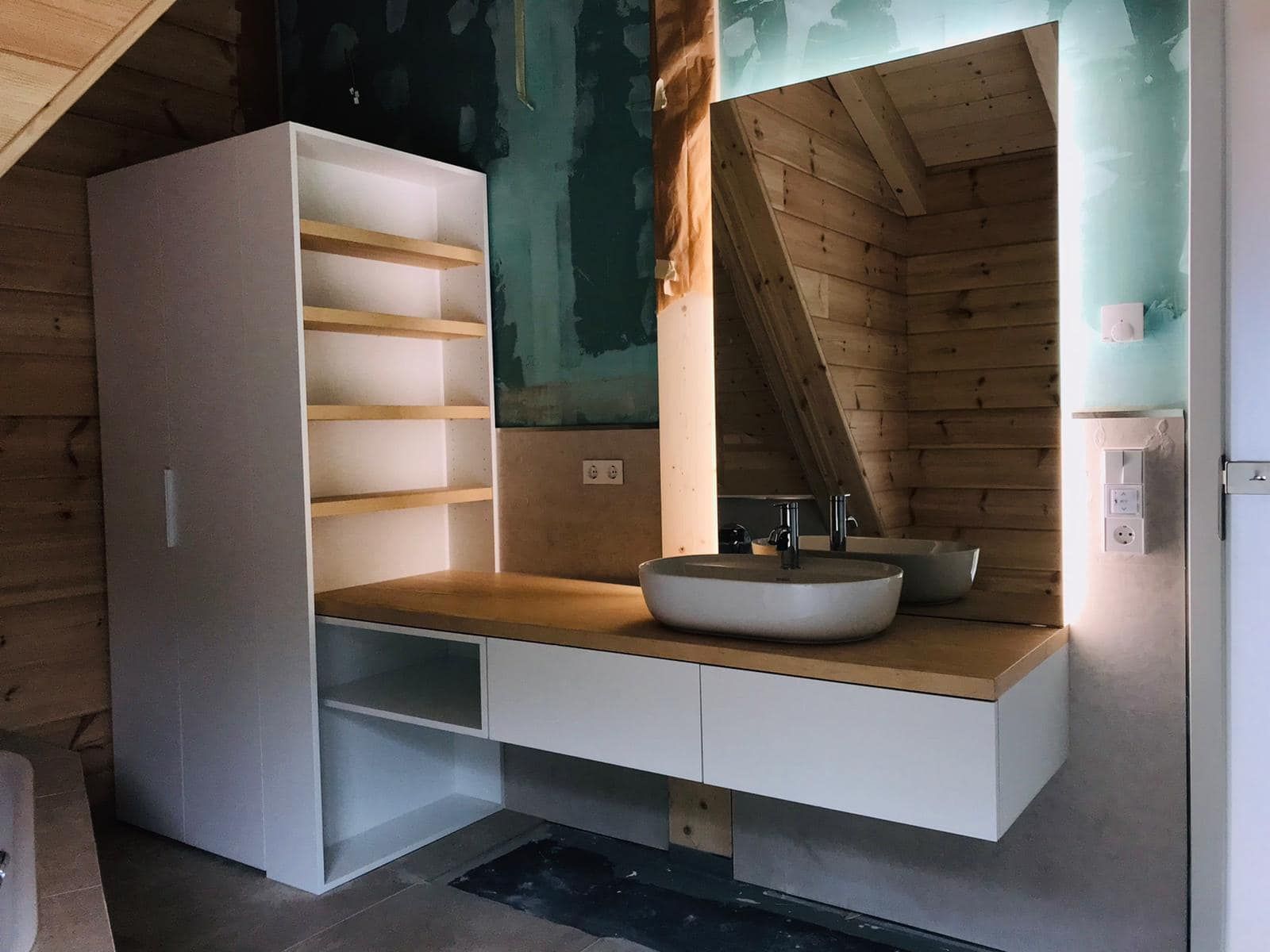 Ein Badezimmer mit Waschbecken, Spiegel und Regalen.