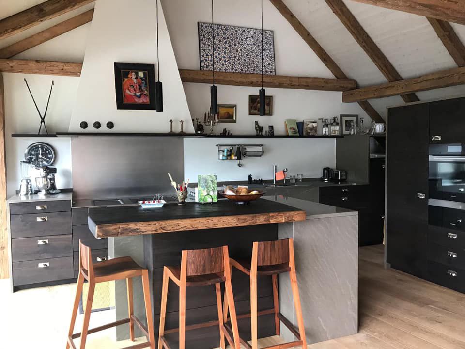 Eine Küche mit Holzinsel und Hockern