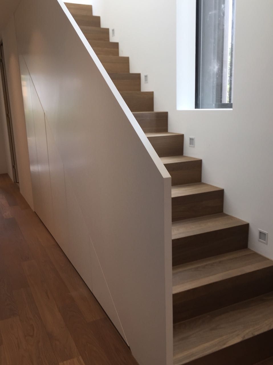 Eine Treppe mit Holzstufen und einem weißen Geländer