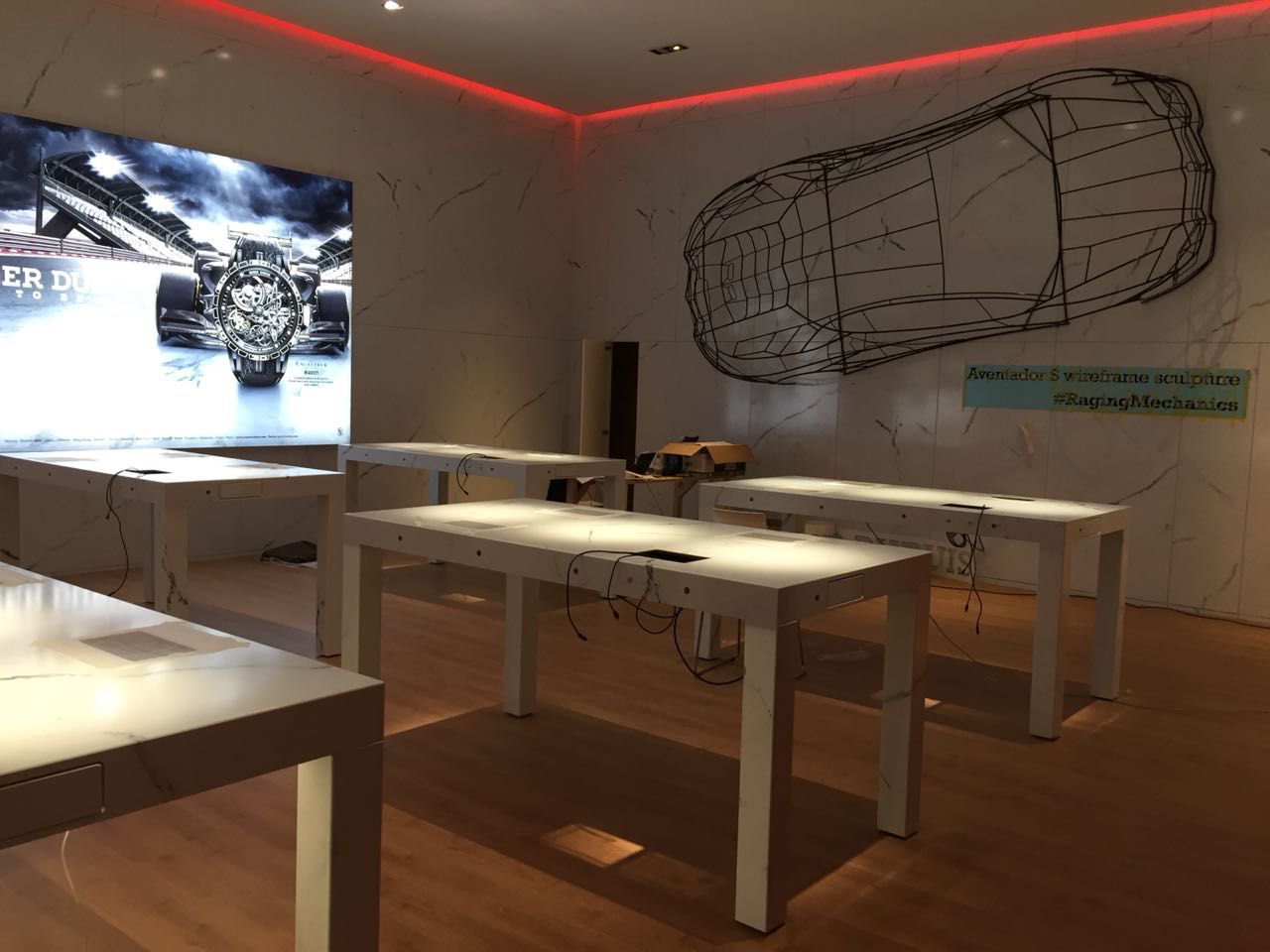 Ein Raum mit Tischen und einer Zeichnung eines Autos an der Wand