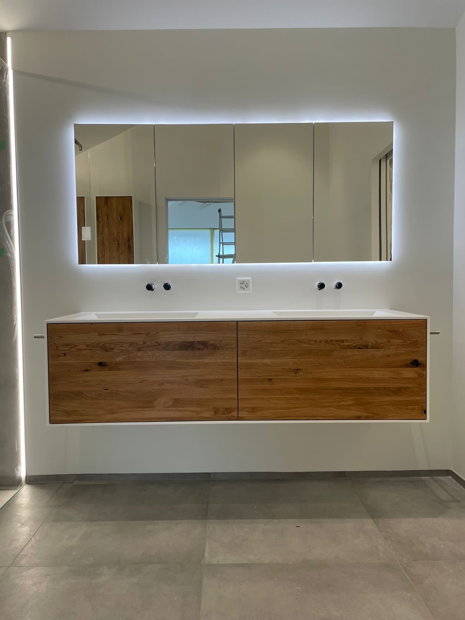 Ein Badezimmer mit zwei Waschbecken und einem großen Spiegel.