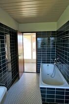 Ein Badezimmer mit Badewanne, Waschbecken und Tür.