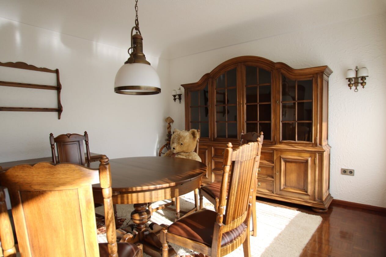 Ein Esszimmer mit einem Tisch und Stühlen und einem Teddybär auf dem Tisch