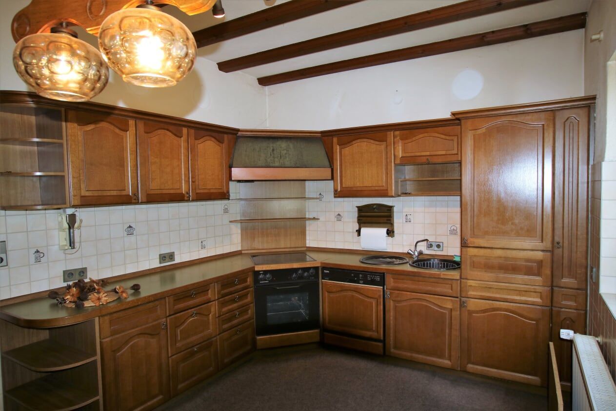 Eine Küche mit Holzschränken und Geräten aus Edelstahl