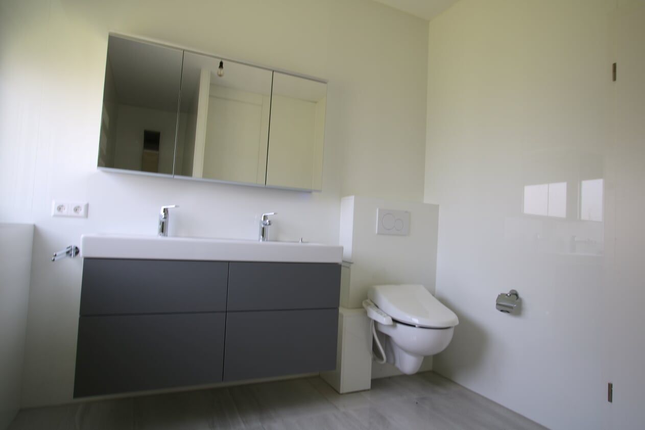 Ein Badezimmer mit Toilette, Waschbecken und Spiegel.