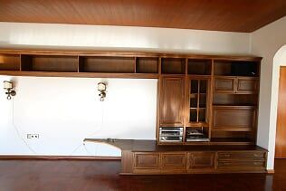 Ein leeres Wohnzimmer mit Holzschränken und einer Holzdecke.