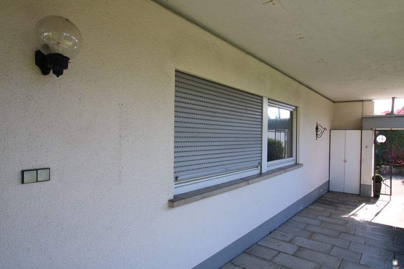 Eine weiße Wand mit zwei Fenstern und einem Licht darauf