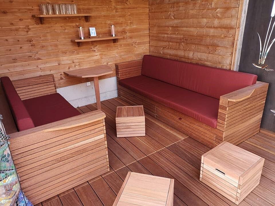 Eine Holzterrasse mit Sofa, Stühlen und Tisch