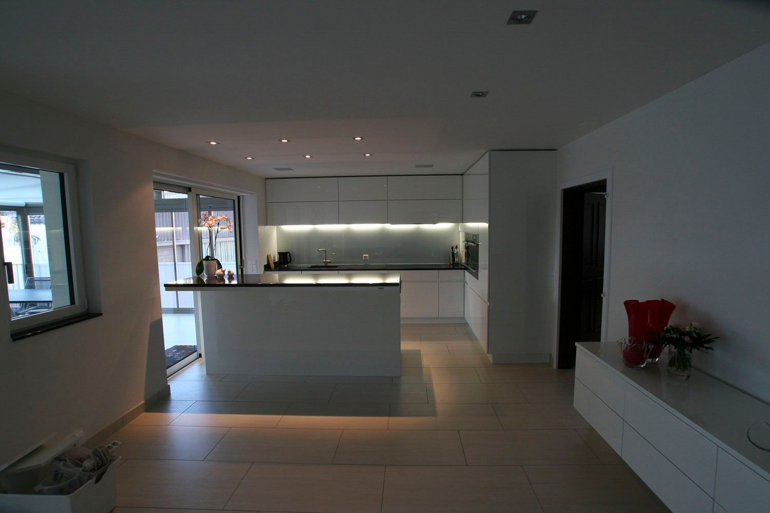 Eine Küche mit weißen Schränken und einer großen Insel in der Mitte