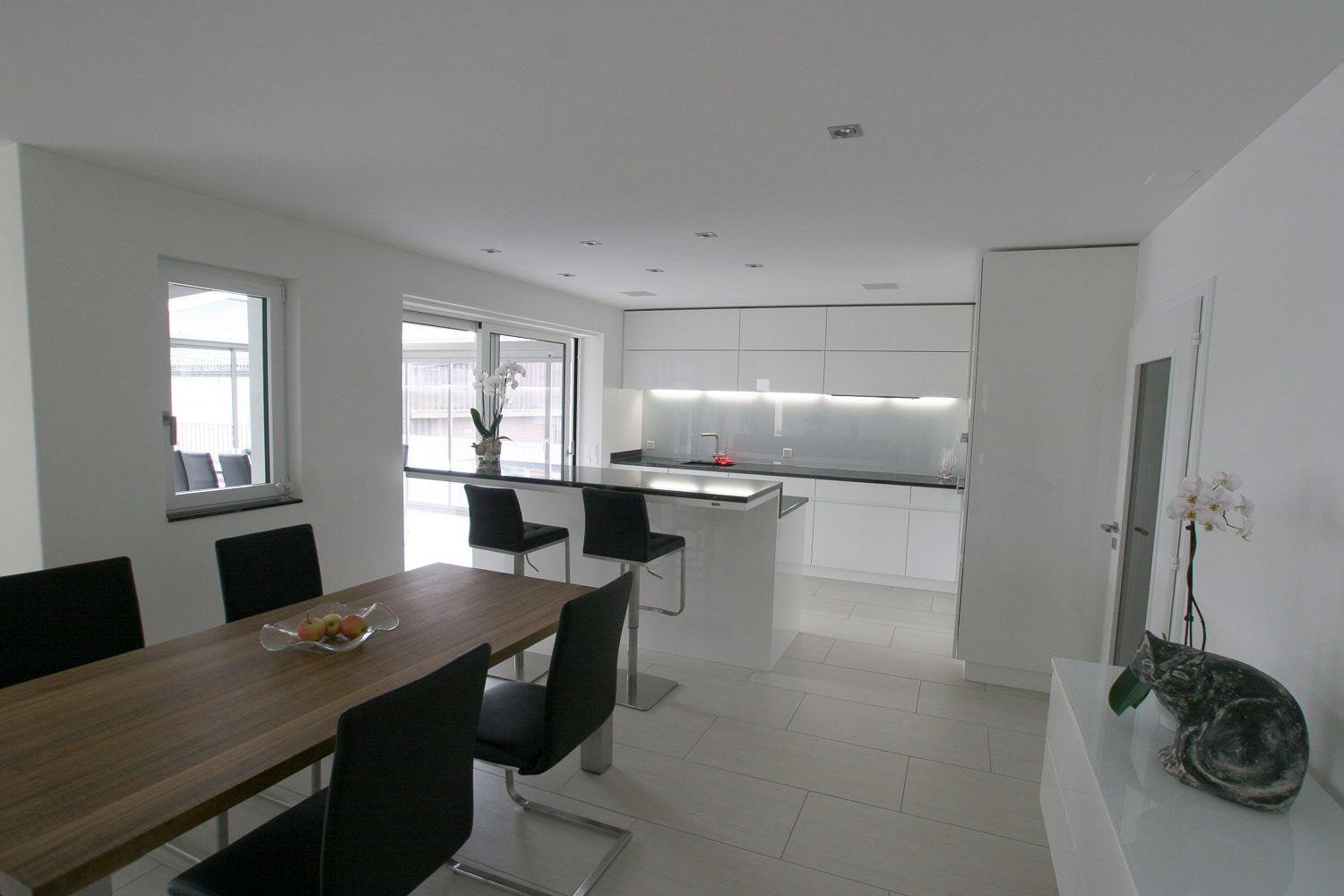 Ein Esszimmer mit Tisch und Stühlen und einer Küche im Hintergrund.