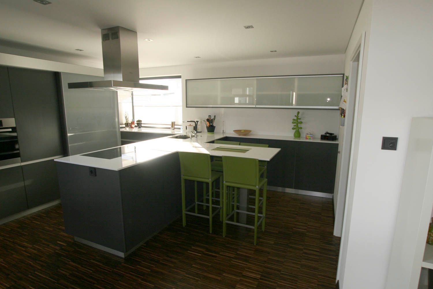 Eine Küche mit einer großen Insel und grünen Stühlen