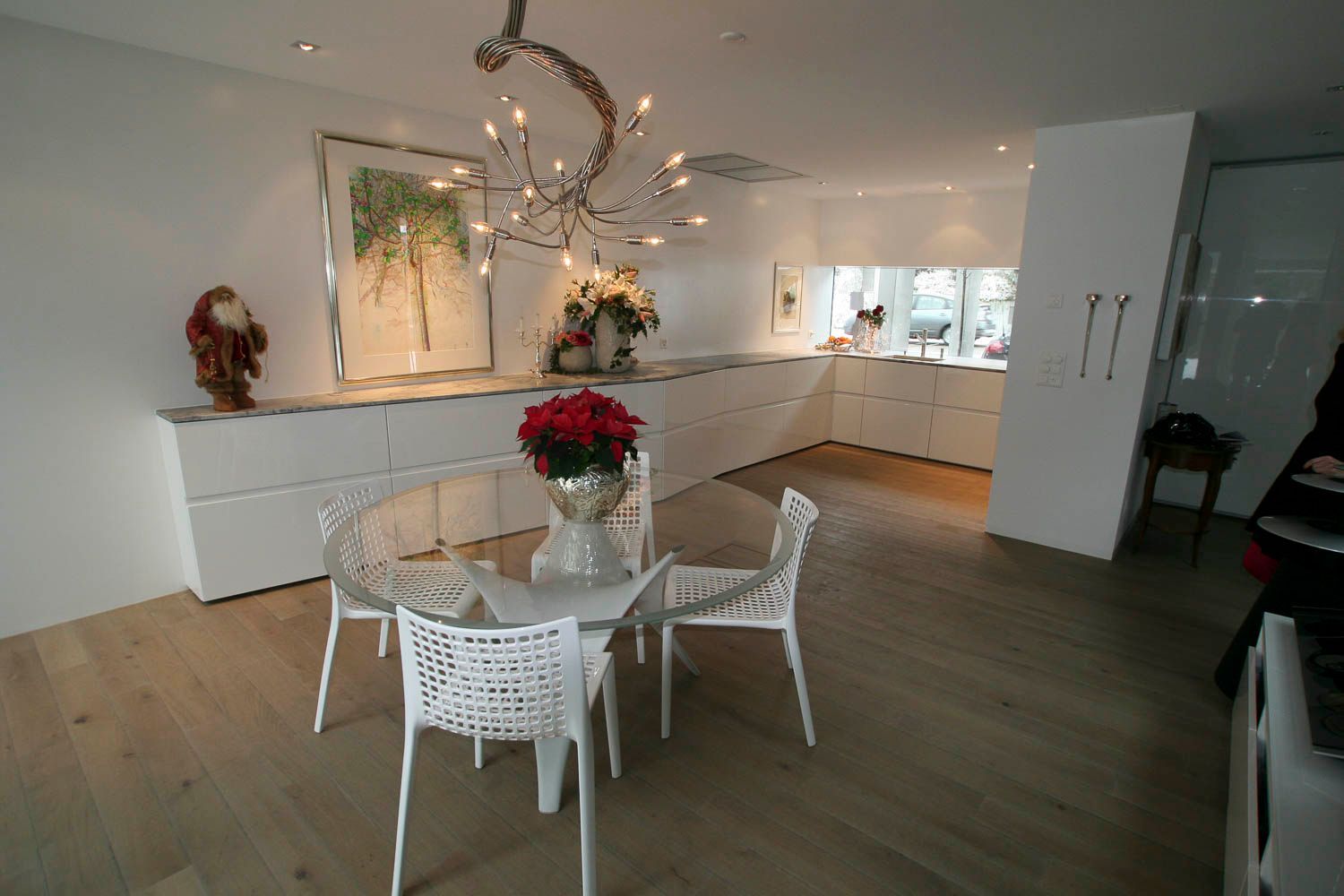 Ein Esszimmer mit einem Tisch und Stühlen und einer Vase mit Blumen.