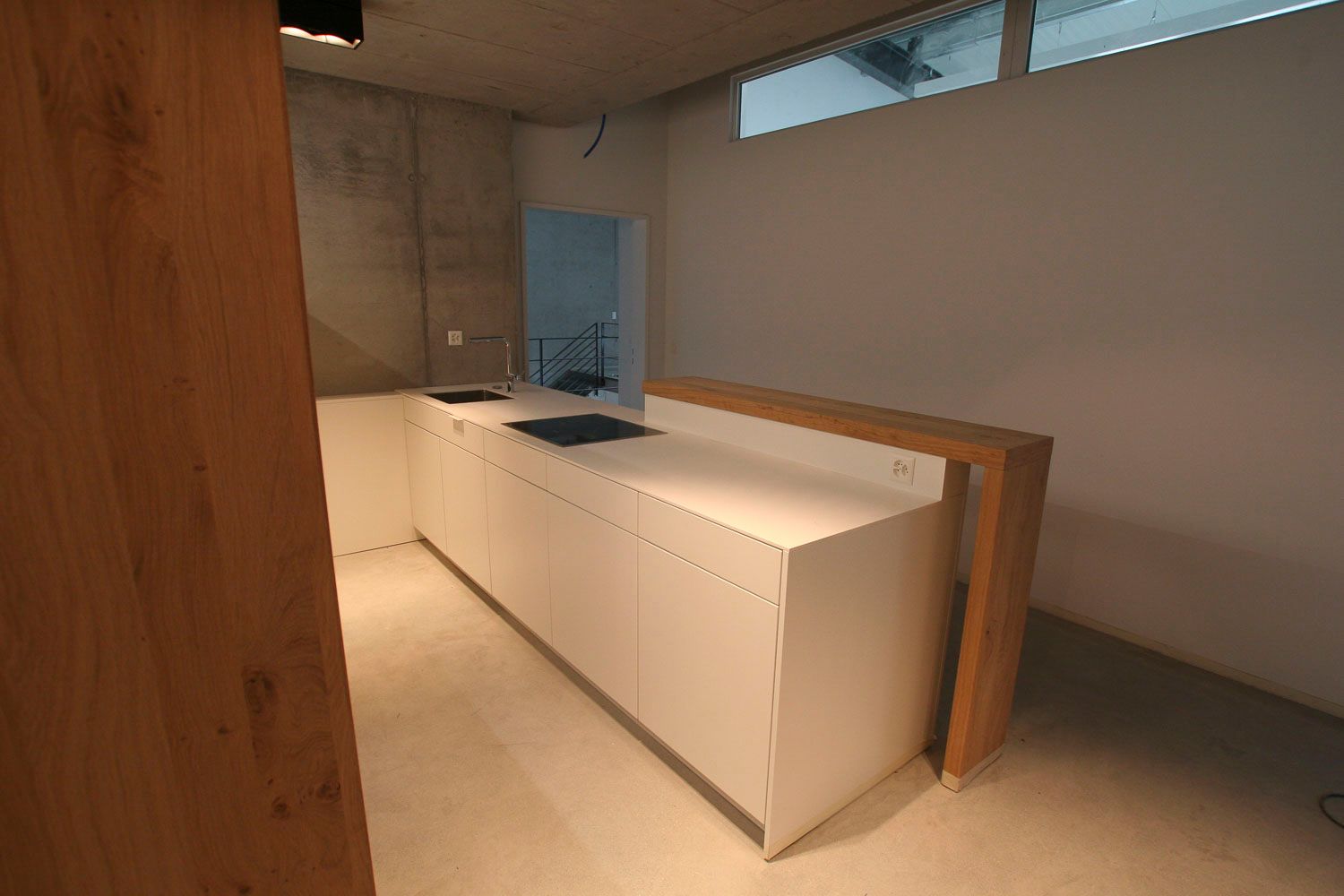 Eine Küche mit weißen Schränken und einer Arbeitsplatte aus Holz