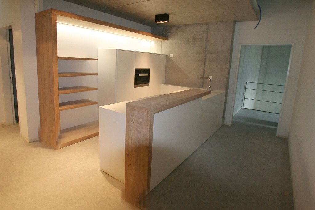 Eine Küche mit weißen Schränken und Holzregalen