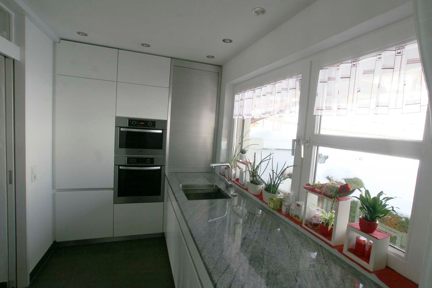 Eine Küche mit weißen Schränken und Geräten aus Edelstahl