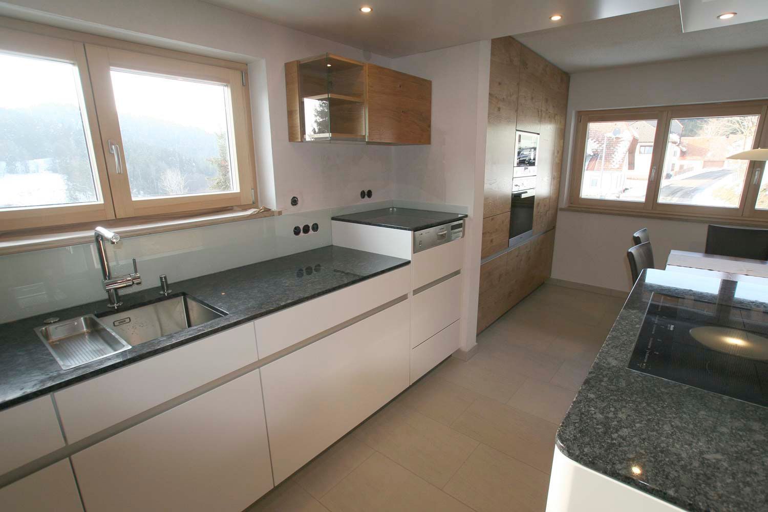 Eine Küche mit Granitarbeitsplatten und weißen Schränken