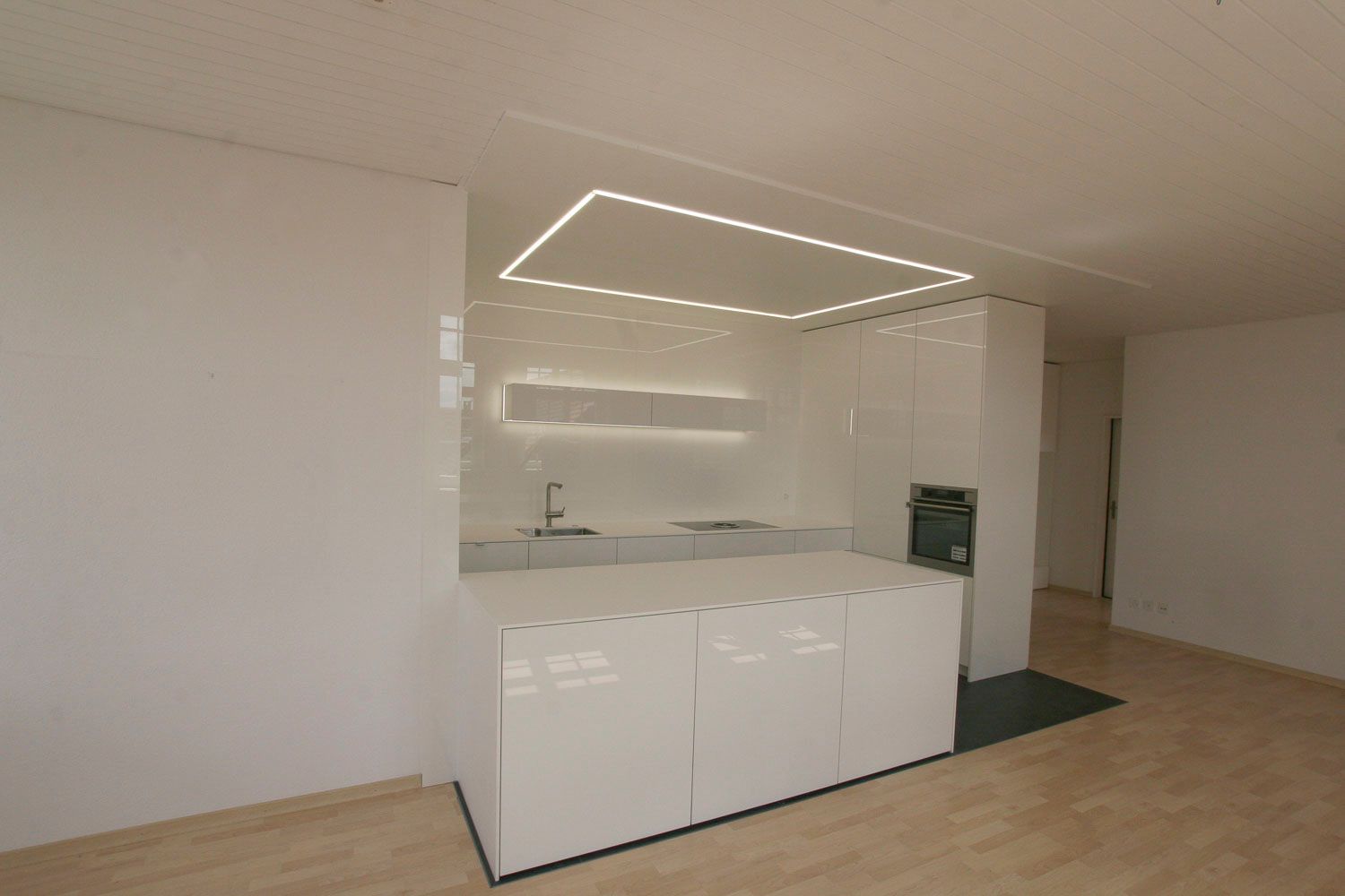 Eine Küche mit weißen Schränken und einer Deckenleuchte