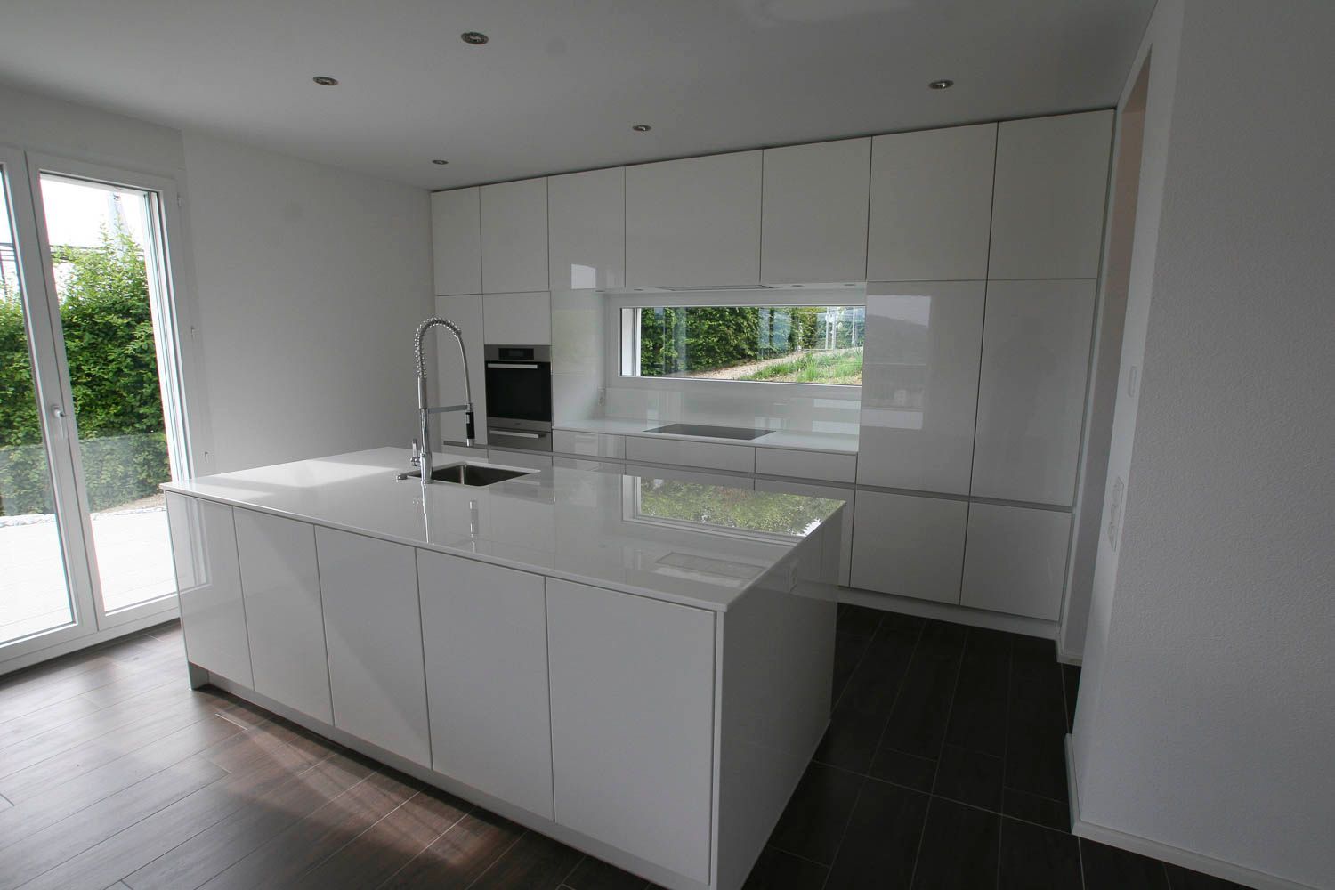 Eine Küche mit weißen Schränken und einer großen Insel in der Mitte