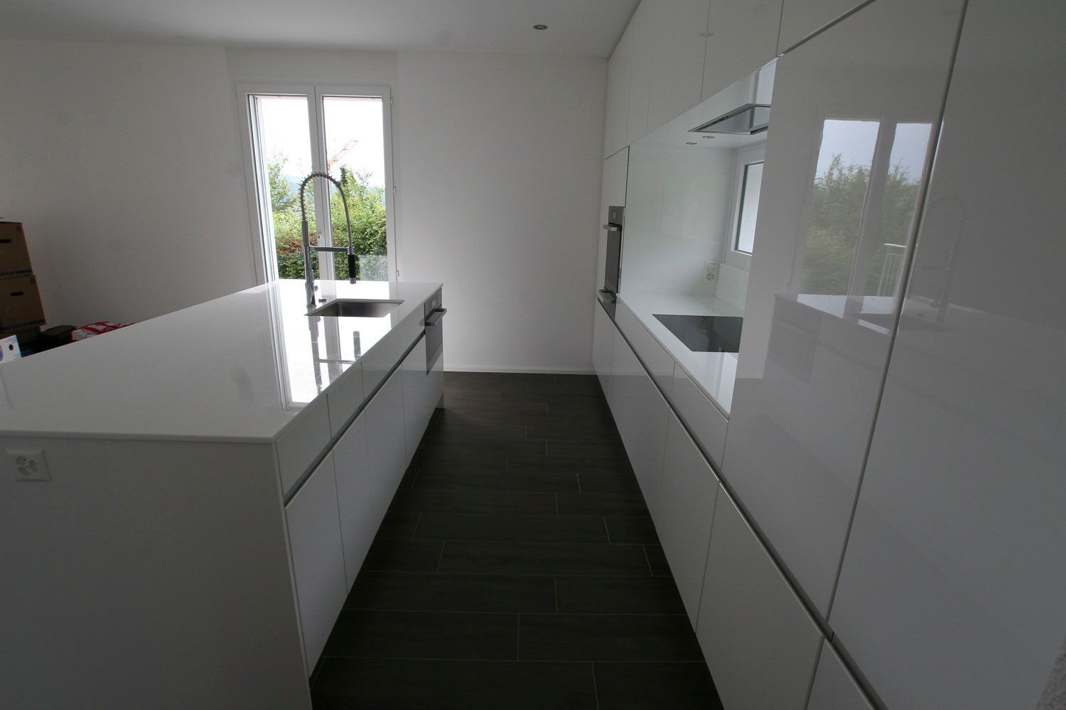 Eine Küche mit weißen Schränken und einer großen Insel in der Mitte.