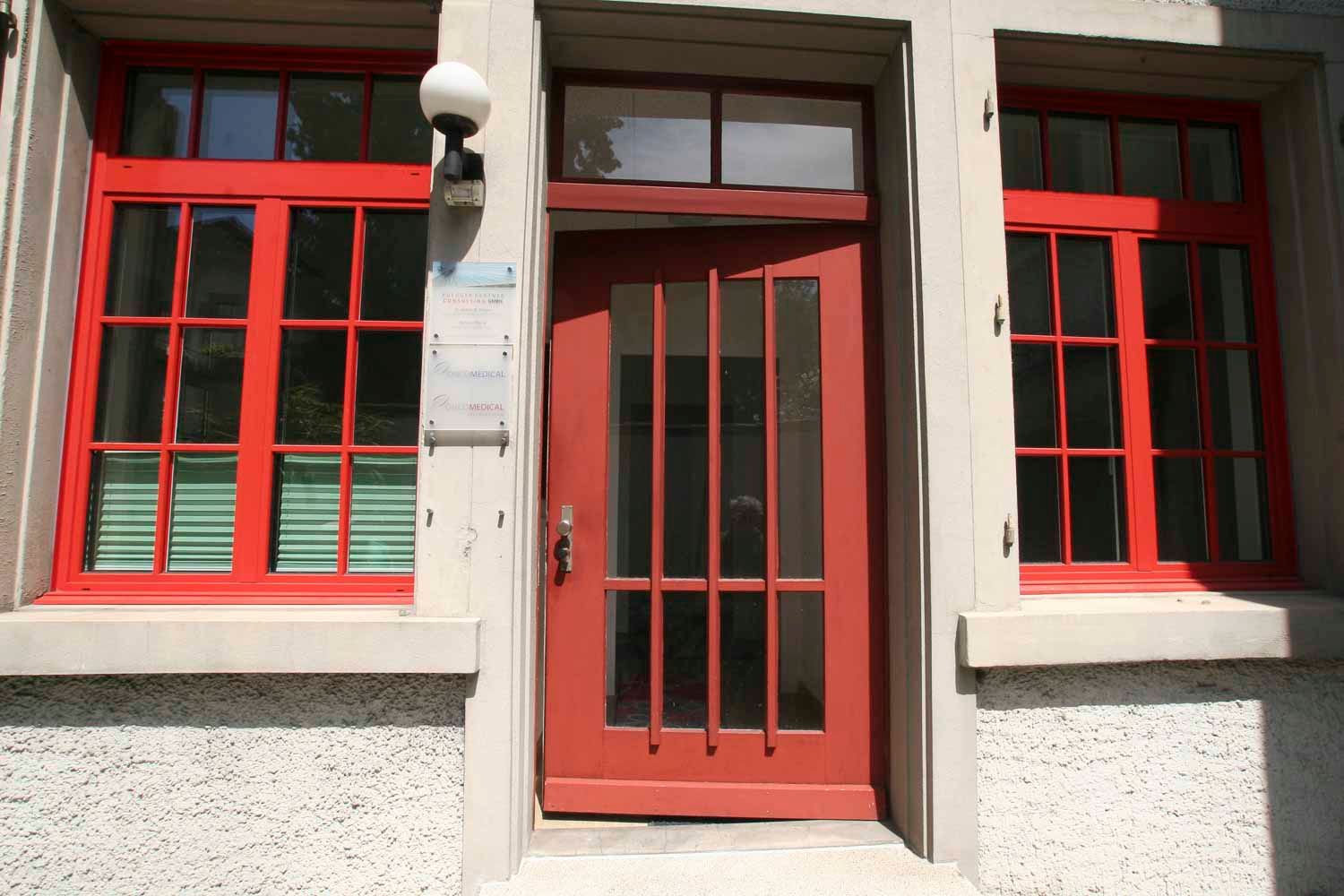 Ein Gebäude mit roten Fenstern und einer roten Tür