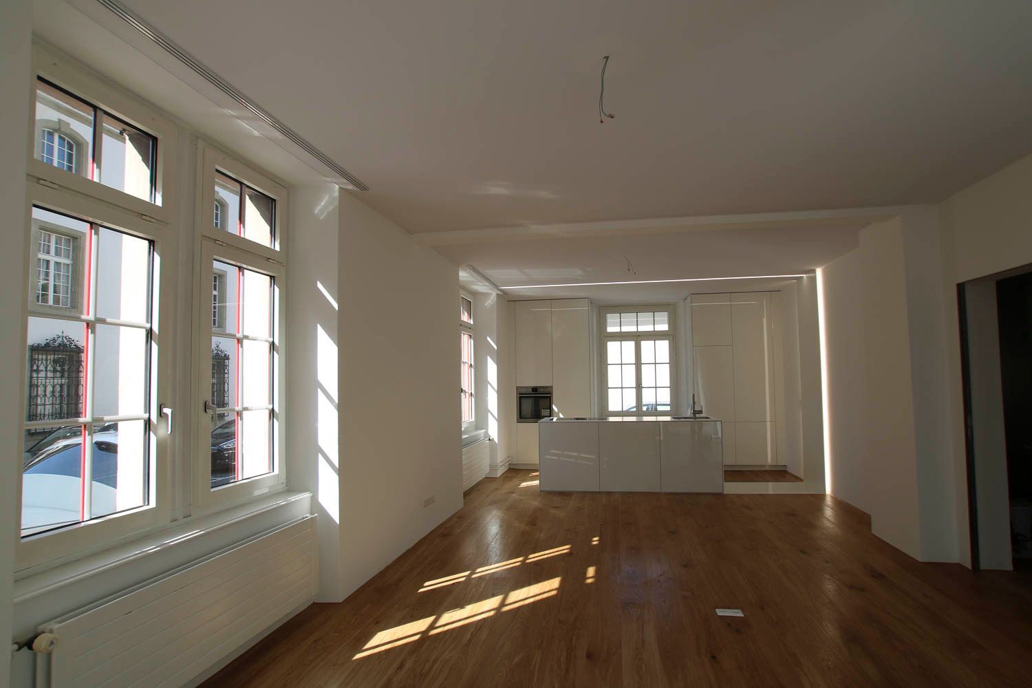 Ein leerer Raum mit Hartholzböden und weißen Wänden
