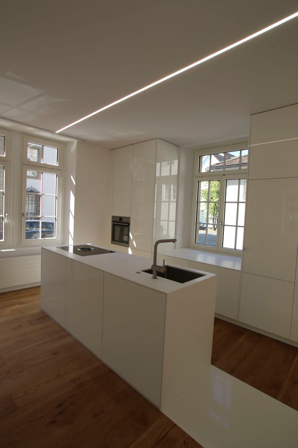 Eine Küche mit weißen Schränken und einer großen Insel in der Mitte