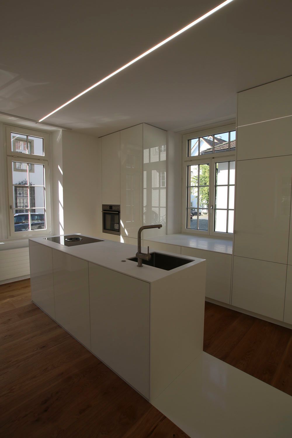 Eine Küche mit weißen Schränken und einer großen Insel in der Mitte