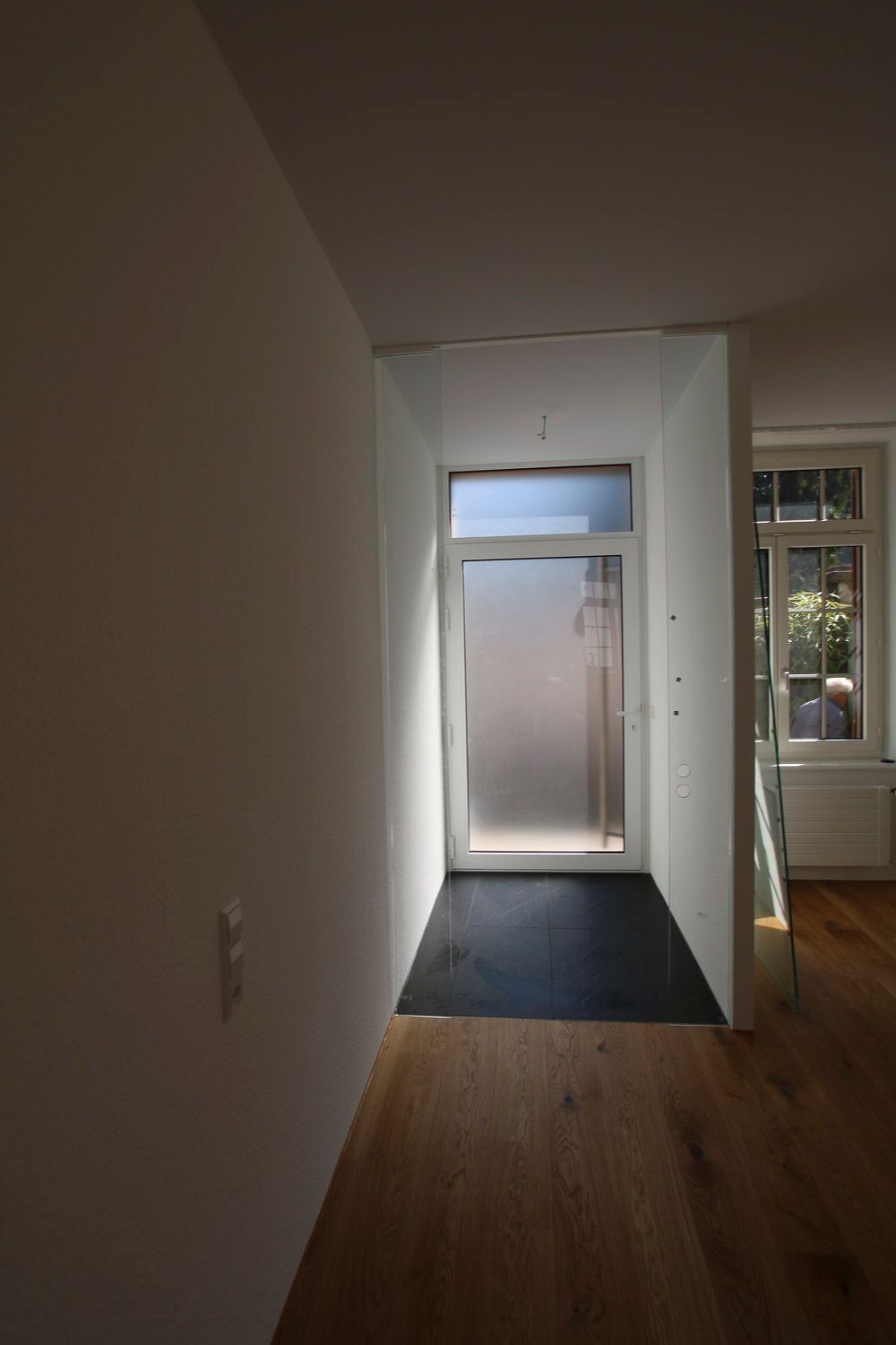 Ein Flur mit einer Glastür und einem Fenster