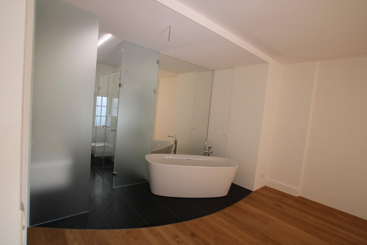 Ein Badezimmer mit Badewanne und ebenerdiger Dusche.