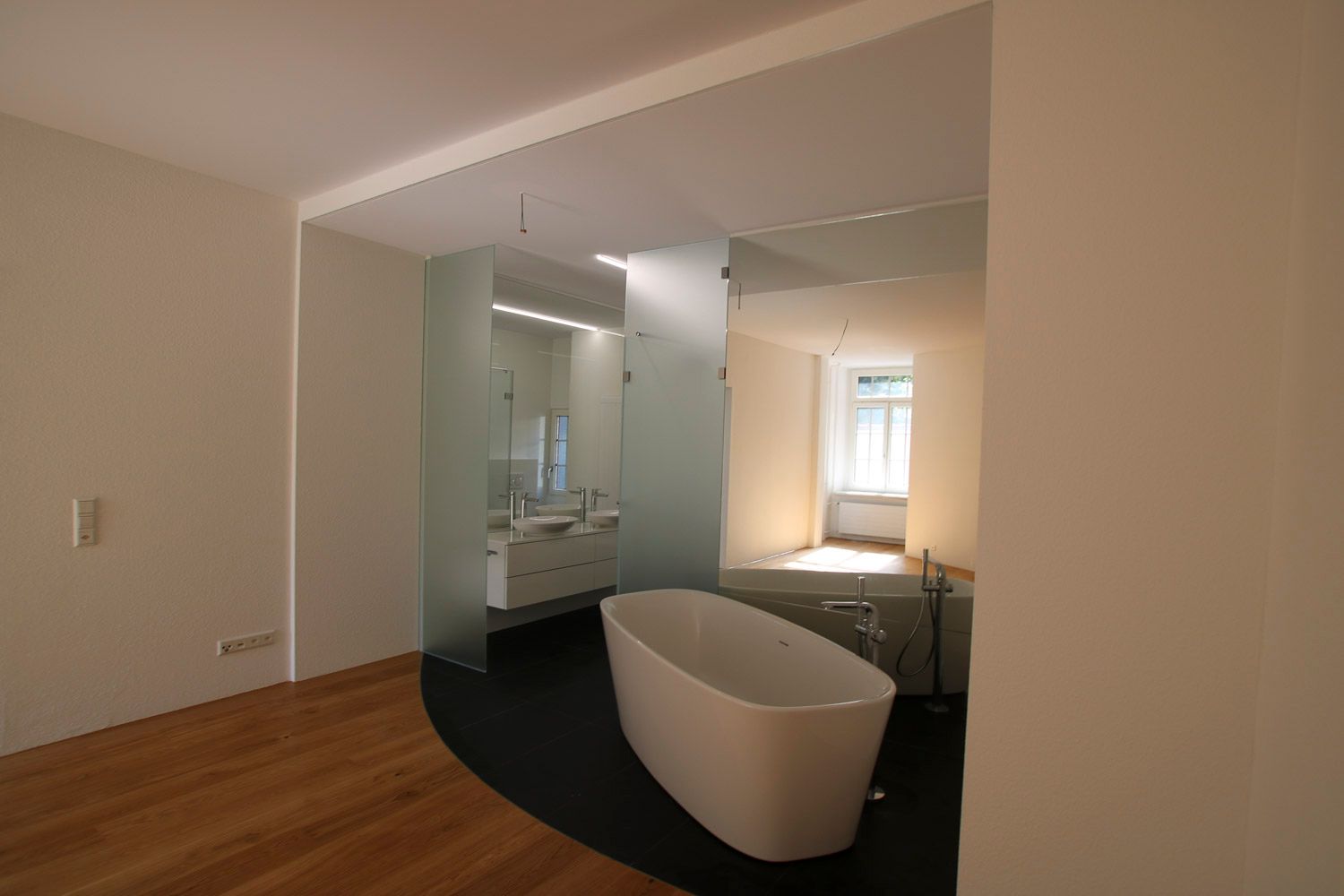 In der Mitte des Badezimmers befindet sich eine Badewanne.