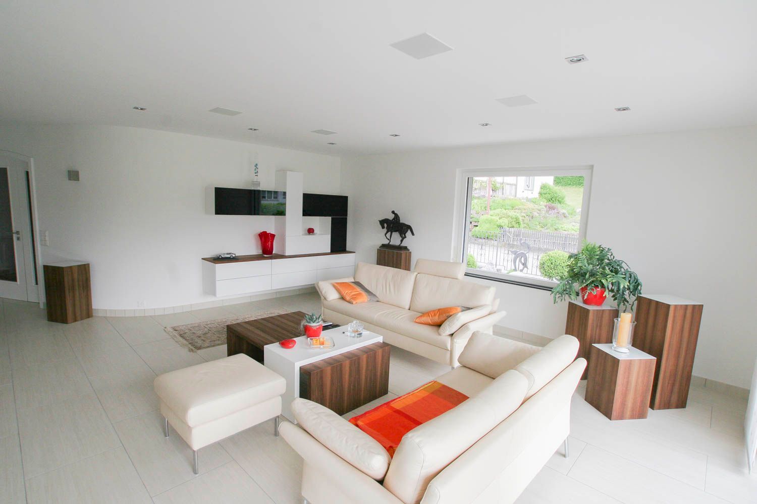 Ein Wohnzimmer mit weißen Möbeln und einem großen Fenster