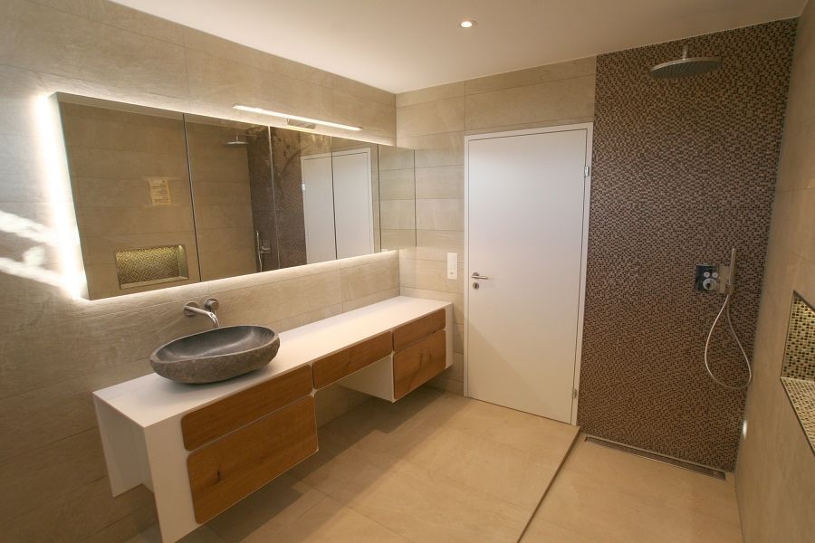 Ein Badezimmer mit Waschbecken, Spiegel und Dusche.