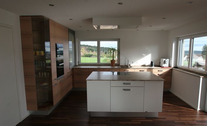 Eine Küche mit weißen Schränken und einer großen Insel in der Mitte