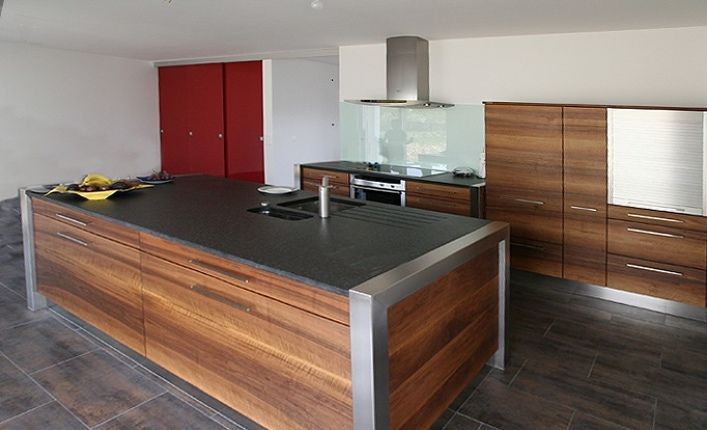 Eine Küche mit Holzschränken und einer schwarzen Arbeitsplatte