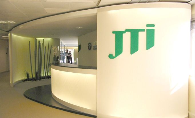 Ein grünes JTI-Logo befindet sich auf einer weißen Wand