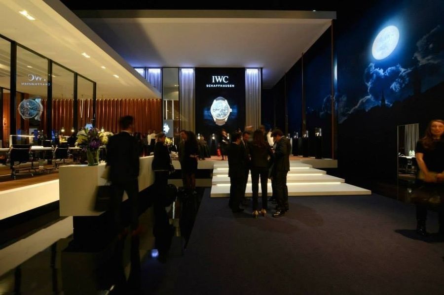 Eine Gruppe von Menschen steht vor einem Schild mit der Aufschrift „IWC“