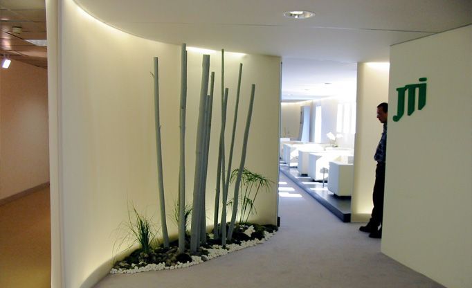 Ein Mann steht in einem Flur mit einem Schild mit der Aufschrift „jmi“