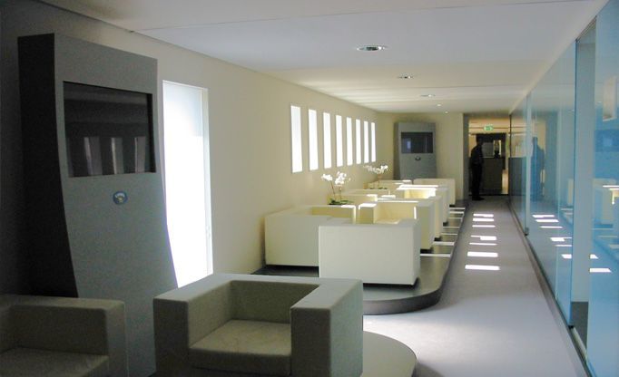 Ein langer Flur mit Stühlen und einem Fernseher an der Wand