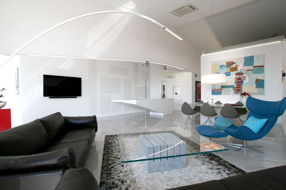 Ein Wohnzimmer mit einer schwarzen Couch und einem blauen Sessel