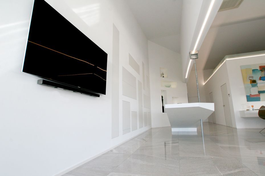 Ein großer Flachbildfernseher ist an einer weißen Wand montiert