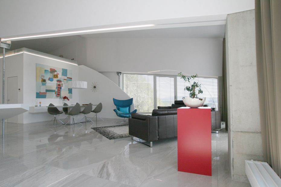 Ein Wohnzimmer mit einer Couch und Stühlen und einer roten Säule