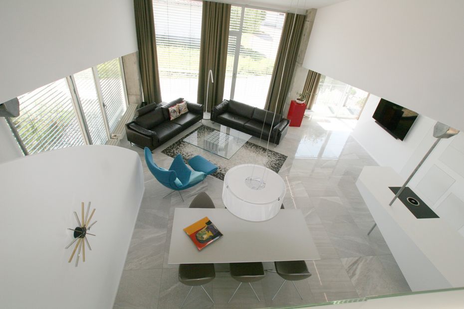 Eine Luftaufnahme eines Wohnzimmers mit einer Couch und Stühlen