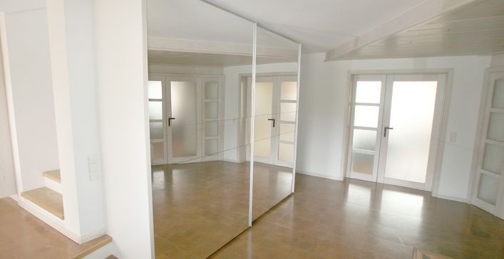 In der Mitte des Zimmers hängt ein großer Spiegel.