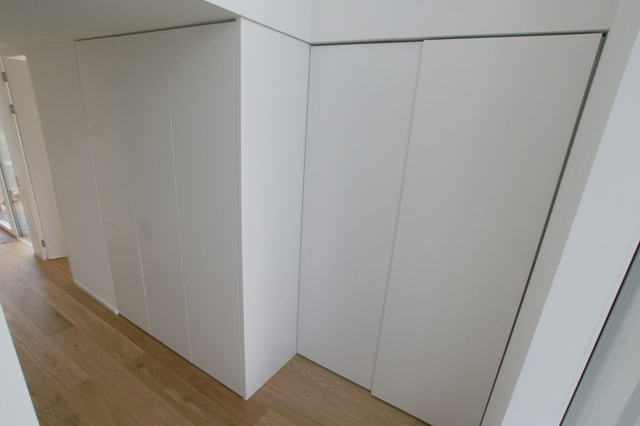 Ein Flur mit weißen Schränken und Holzböden