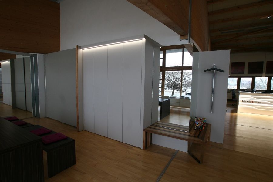 Ein Raum mit einer Bank und einem Kreuz an der Wand