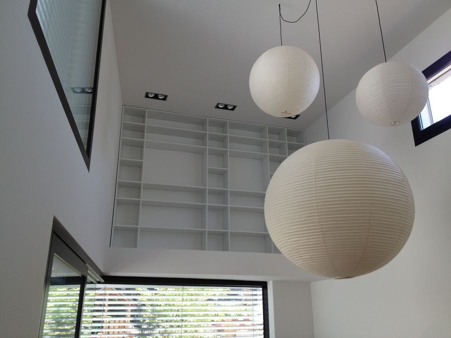 Ein Raum mit vielen Regalen und ein paar Lampen, die von der Decke hängen